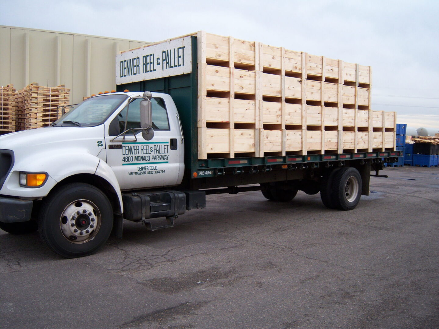 A white truck with wooden crates on the back of it.