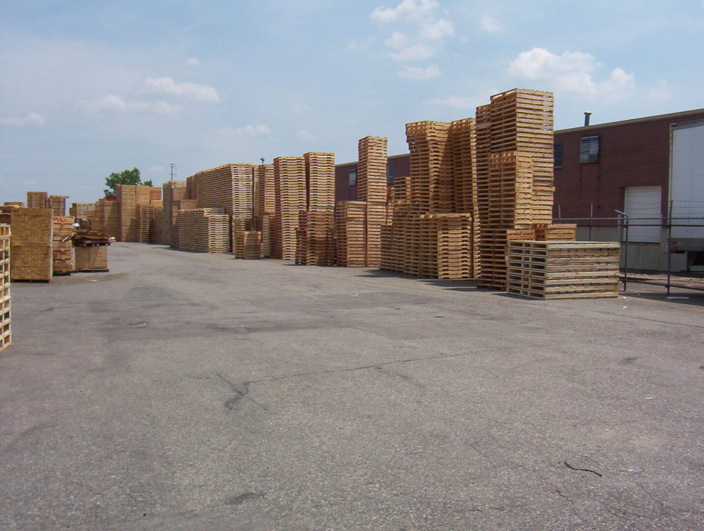 A lot of wood stacked up in the middle of a parking lot.