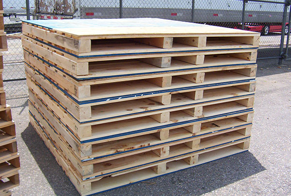 A stack of wooden pallets sitting in the middle of a lot.