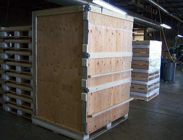 A large wooden crate in the middle of a warehouse.