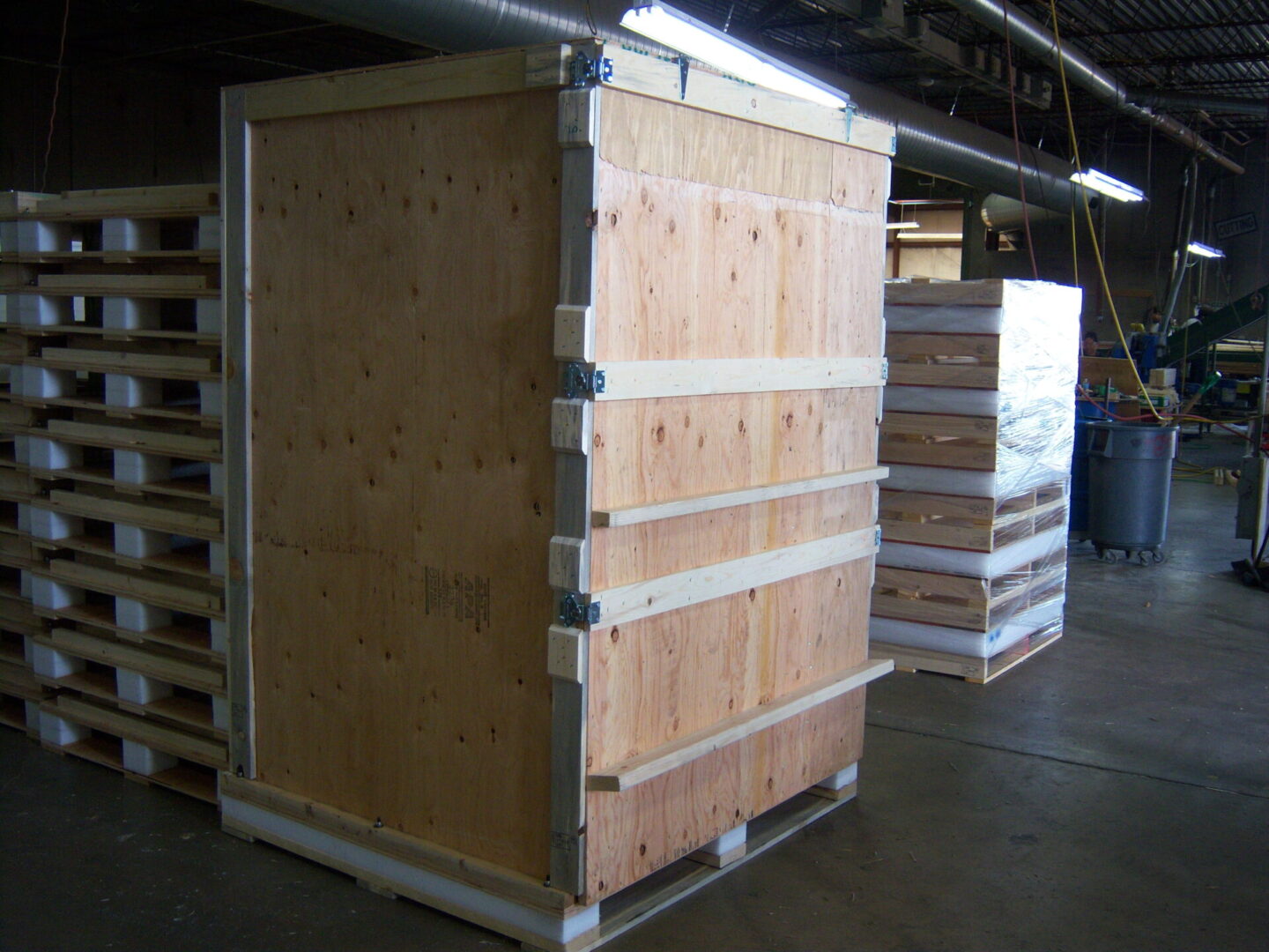 A large wooden crate in the middle of a warehouse.
