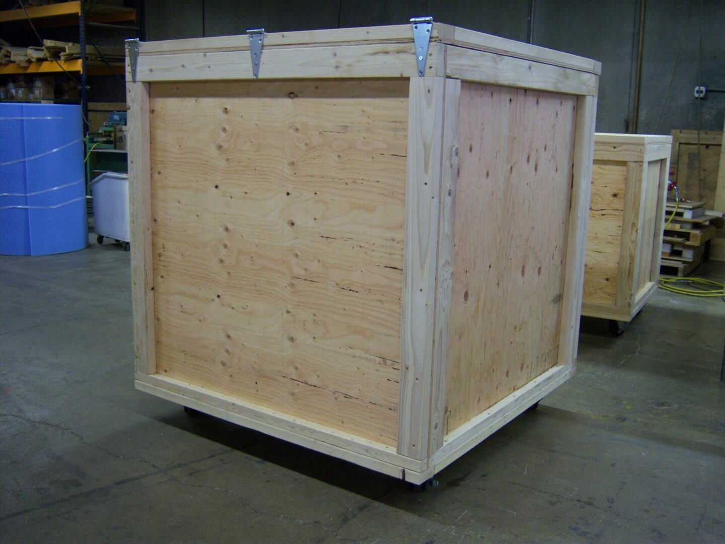 A wooden crate with metal wheels on the side.