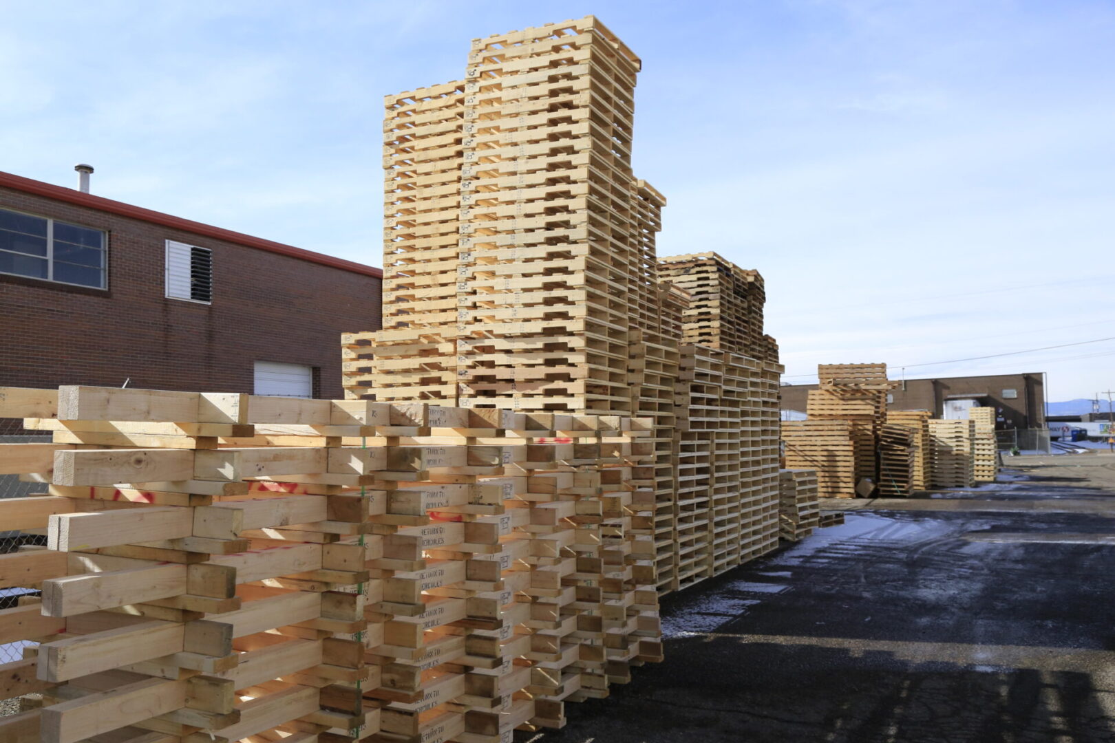 A pile of wooden pallets in the middle of a factory.